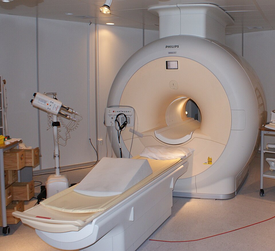 원통형 개구부와 환자용 이동 침대를 갖춘 흰색 MRI 촬영 장치